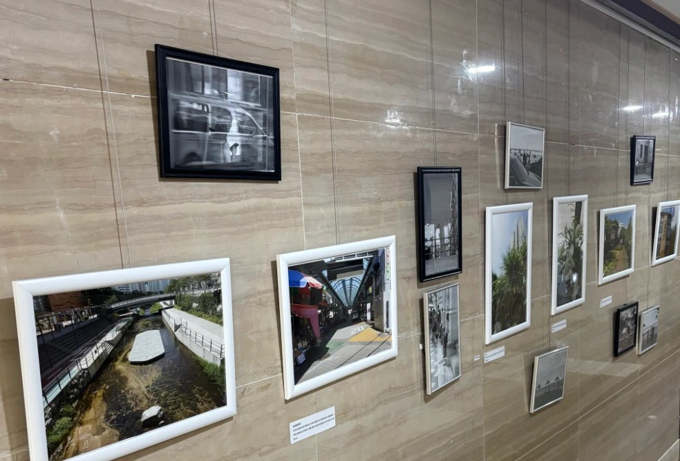 Framed photographs hung along a stone wall at the Busanpest exhibition